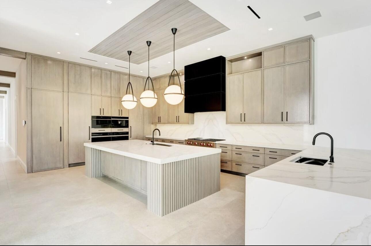 White modern kitchen waterfall island | Sunshine Alliance, Miami