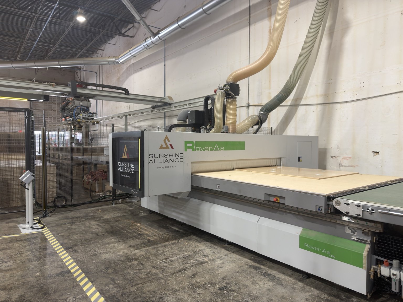 Biesse Rover A CNC router with a panel loaded on the vacuum table, branded Sunshine Alliance guard | Sunshine Alliance, Deerfield Beach FL