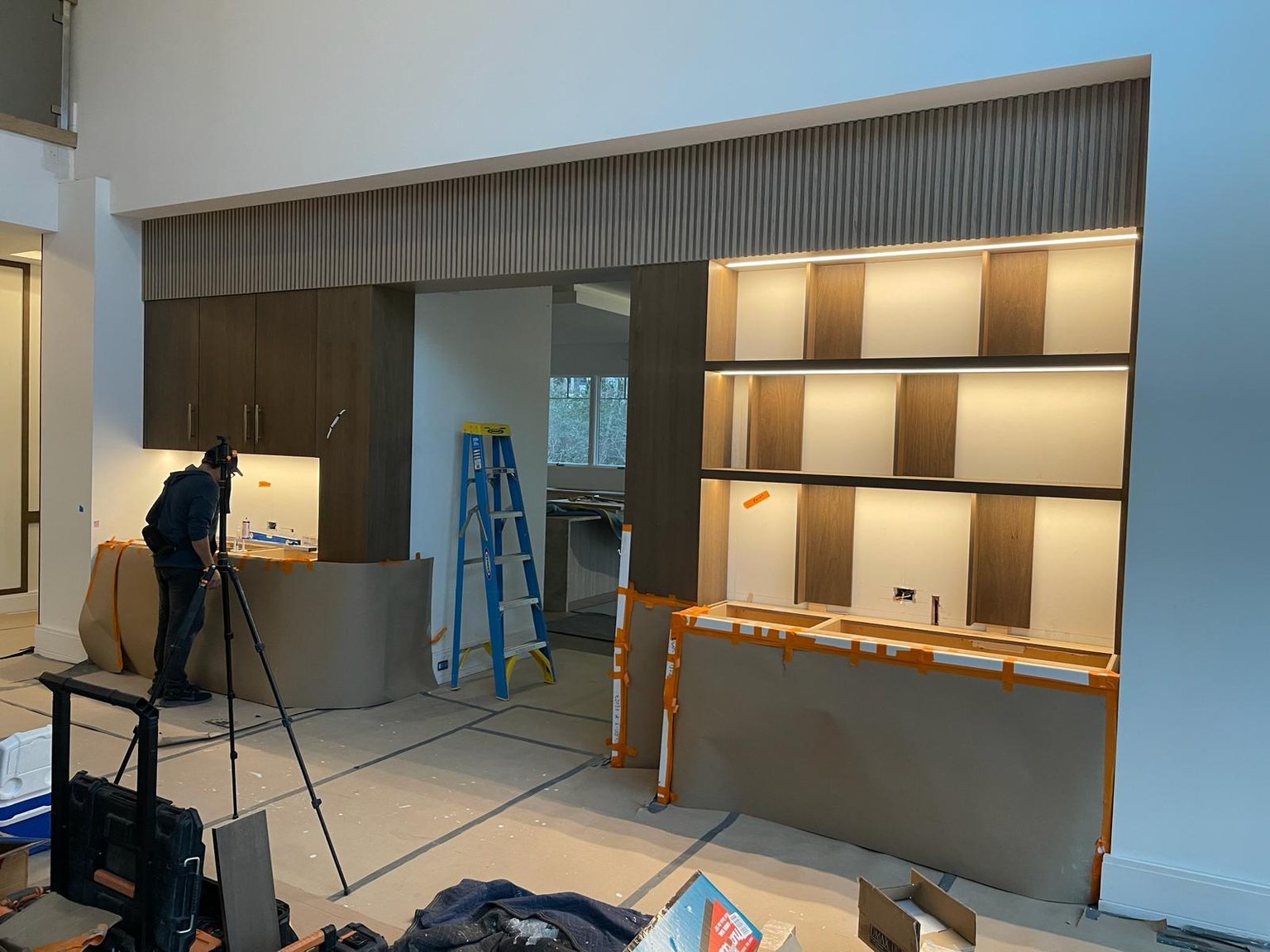The Hamptons media wall under installation with fluted header and lit shelving | Sunshine Alliance, Hamptons NY