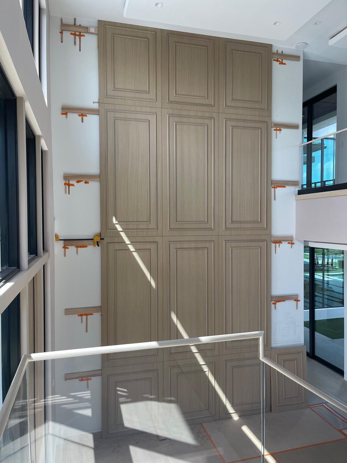 Custom paneled feature wall going up against ledger cleats in a luxury home | Sunshine Alliance, South Florida