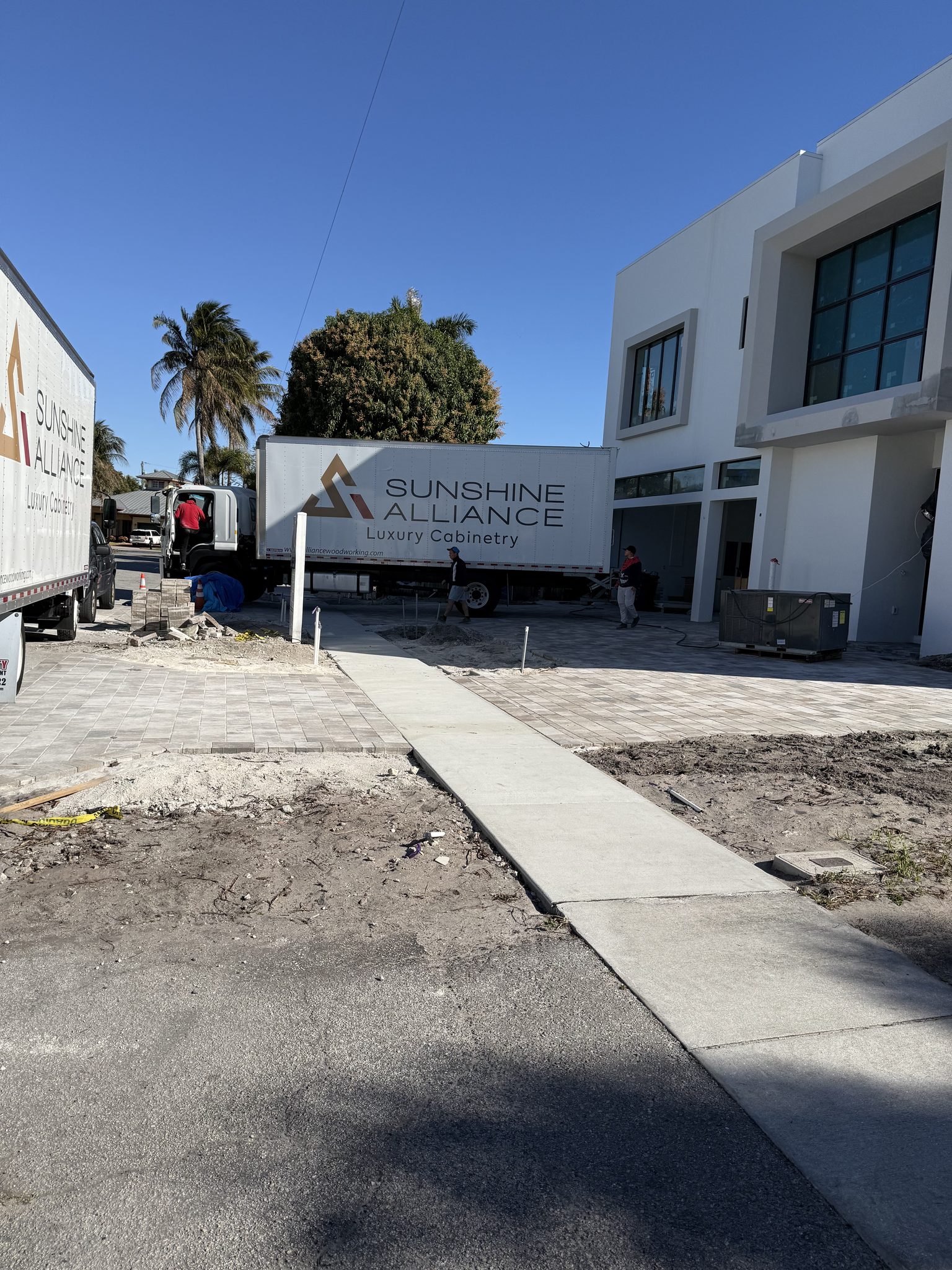 Two Sunshine Alliance box trucks delivering custom cabinetry to a home under construction | Sunshine Alliance, South Florida